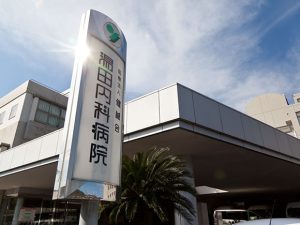 介護施設の建物外観。モダンな建築様式で、看板と駐車場が見える。